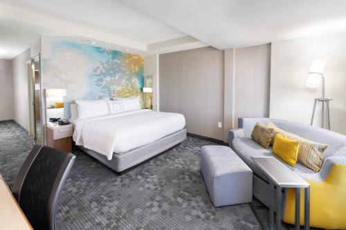 a hotel room with a bed and a couch at Courtyard by Marriott Bowie in Bowie