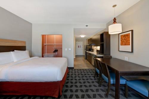 a hotel room with a bed and a desk and a kitchen at TownePlace Suites by Marriott El Paso East/I-10 in El Paso