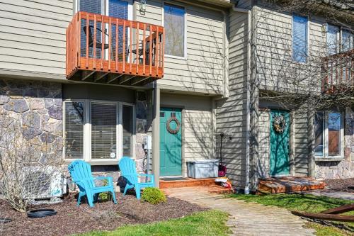 duas cadeiras azuis sentadas em frente a uma casa em Deep Creek Village em McHenry