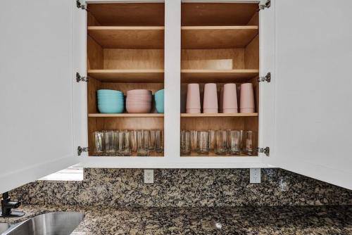 einen Küchenschrank mit Tassen und Geschirr darin in der Unterkunft Water Front Home with Boat Dock Hot Tub Roof Top Fire Pit in Fort Lauderdale