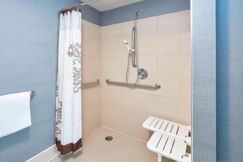 a bathroom with a shower with a toilet and a shower curtain at Residence Inn by Marriott Chicago Schaumburg/Woodfield Mall in Schaumburg