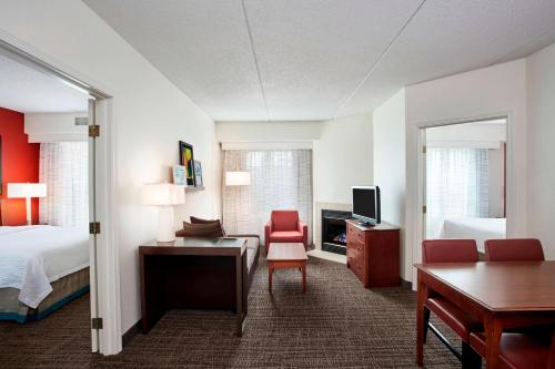 a hotel room with a bedroom with a bed and a desk at Residence Inn by Marriott Chicago Schaumburg/Woodfield Mall in Schaumburg
