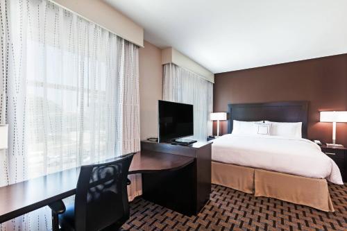 a hotel room with a bed and a desk with a television at Residence Inn by Marriott Austin Northwest/The Domain Area in Austin