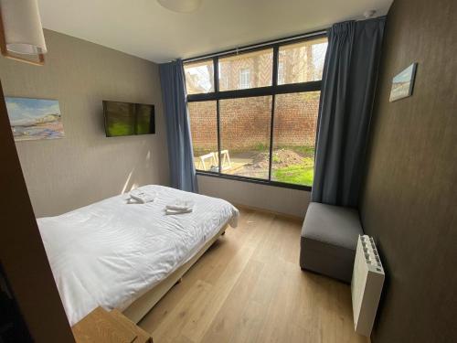 a bedroom with a bed and a large window at Parc Beausejour Aparthotel in Dieppe