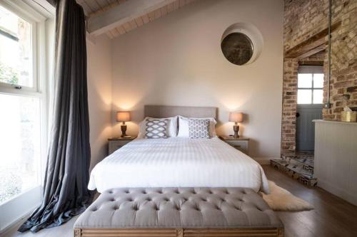 1 dormitorio con 1 cama grande y 2 ventanas en The Mews -- Luxury Stay at Bellingham Estate en Castlebellingham