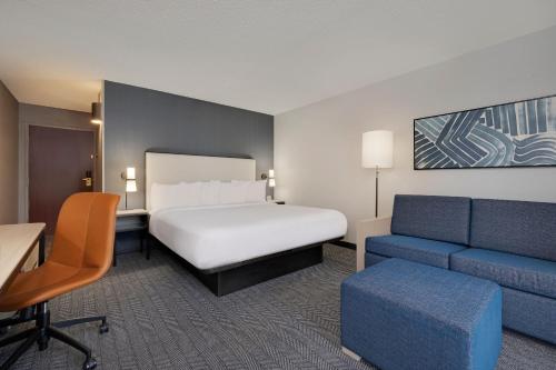 Courtyard by Marriott Indianapolis South في انديانابوليس: غرفه فندقيه بسرير واريكه