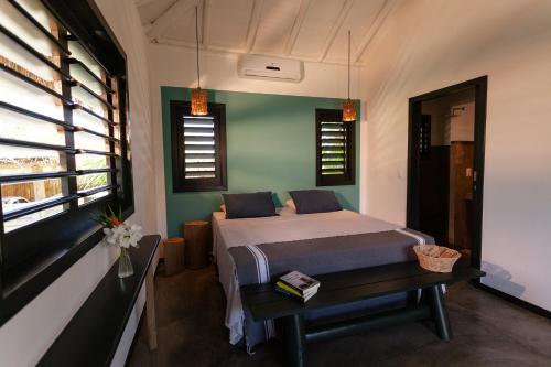 a bedroom with a bed and a table and windows at Hotel & Restaurante VilaVeraTheresa in Fortim