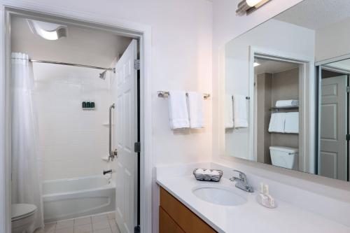 uma casa de banho branca com um lavatório e um espelho em Residence Inn Wayne em Wayne