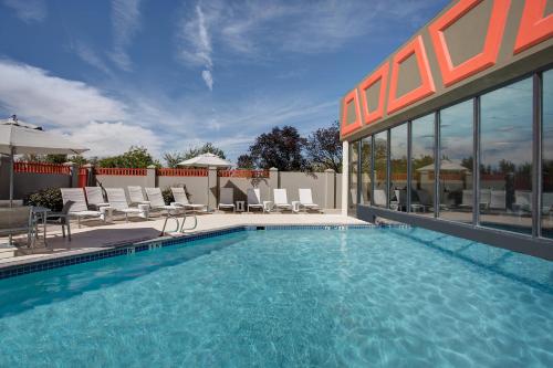 una piscina con sillas y un edificio en Albuquerque Marriott Pyramid North, en Albuquerque