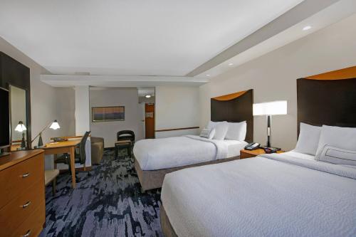 a hotel room with two beds and a desk at Fairfield Inn and Suites Carlsbad in Carlsbad