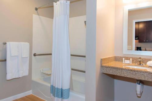 een badkamer met een douchegordijn en een wastafel bij TownePlace Suites Fort Wayne North in Fort Wayne