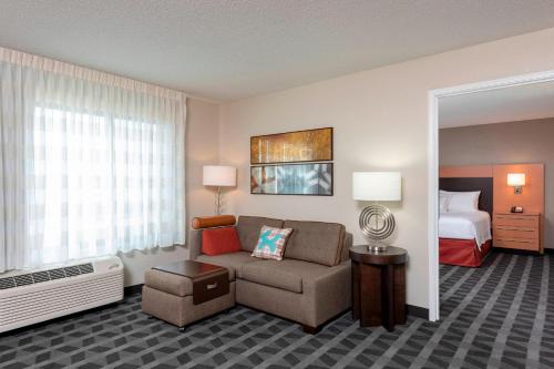 um quarto de hotel com um sofá e uma cama em TownePlace Suites Fort Wayne North em Fort Wayne