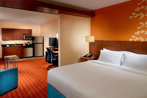 a hotel room with a bed and a kitchen at Fairfield Inn & Suites by Marriott Fayetteville North in Fayetteville