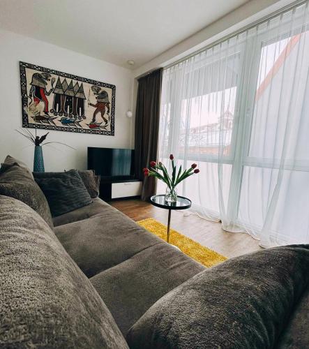 un soggiorno con divano e una grande finestra di Castle Apartaments host Kaunas with free parking a Kaunas