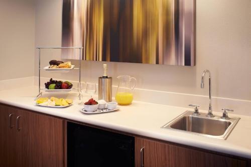 a kitchen counter with a sink and a plate of fruit at Courtyard Cincinnati Covington in Covington