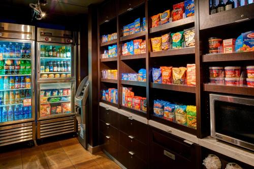 a kitchen with a refrigerator and lots of food at Courtyard Cincinnati Covington in Covington