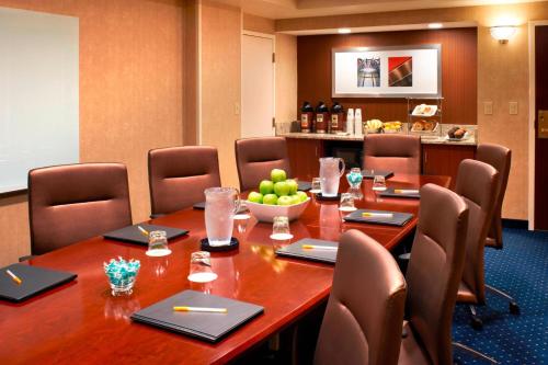a conference room with a large wooden table and chairs at Courtyard Cincinnati Covington in Covington