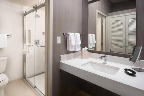 a bathroom with a sink and a toilet and a mirror at Courtyard by Marriott Phoenix Mesa in Mesa