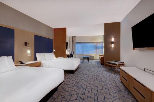 a hotel room with two beds and a flat screen tv at Fairfield by Marriott Inn & Suites Minneapolis Downtown in Minneapolis