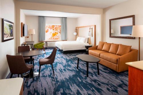 ナパにあるFairfield Inn and Suites by Marriott Napa American Canyonのソファ、ベッド、テーブルが備わるホテルルームです。