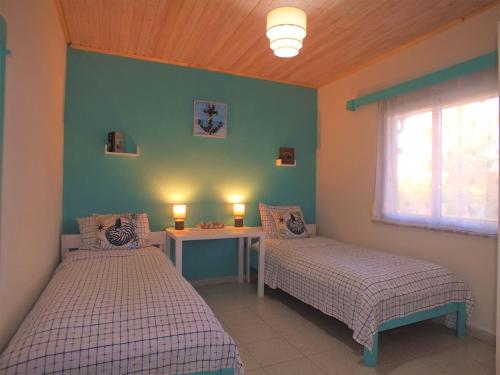 een slaapkamer met 2 bedden, een tafel en een raam bij Asprovalta Family Villas in Asprovalta
