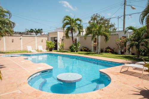 a swimming pool with blue water in a yard at Casa privada con alberca grande in Chetumal