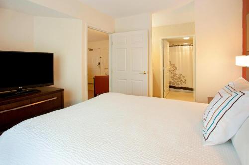 Schlafzimmer mit einem Bett und einem Flachbild-TV in der Unterkunft Residence Inn Fort Wayne Southwest in Fort Wayne