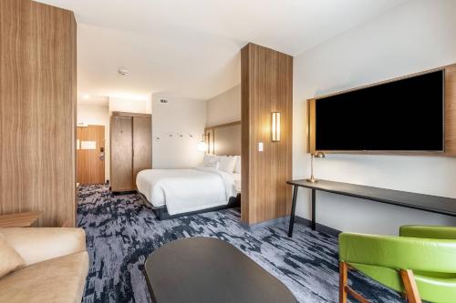 a hotel room with a bed and a flat screen tv at Fairfield Inn & Suites by Marriott Dallas DFW Airport North Coppell Grapevine in Coppell