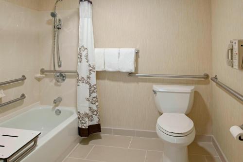 a bathroom with a toilet and a bath tub with a shower curtain at Residence Inn Fort Wayne Southwest in Fort Wayne