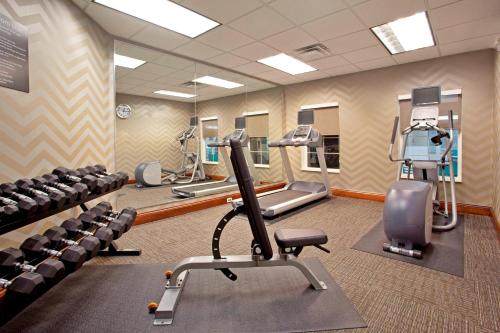a gym with treadmills and elliptical machines and chairs at Residence Inn Fort Wayne Southwest in Fort Wayne