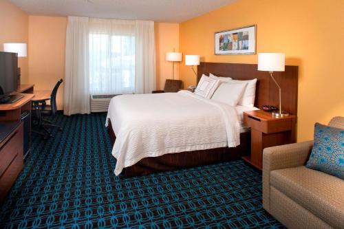 a hotel room with a bed and a couch and a television at Fairfield Inn by Marriott Denver / Westminster in Westminster