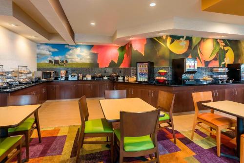 a restaurant with tables and chairs and a counter at Fairfield Inn & Suites Jackson in Jackson