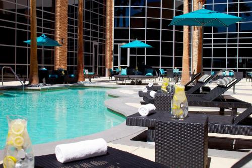 a swimming pool with chairs and umbrellas in a hotel at Renaissance Las Vegas Hotel in Las Vegas