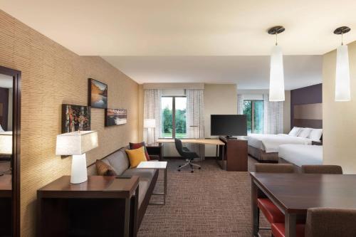 une chambre d'hôtel avec un lit et un salon dans l'établissement Residence Inn By Marriott Greenville, à Greenville