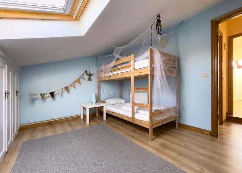 ein Schlafzimmer mit Etagenbetten in einem Zimmer mit blauen Wänden in der Unterkunft Villa de Melle – Seaview – beach 5 min by foot in Ferrol