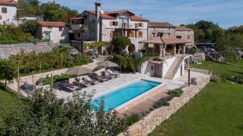 an estate with a swimming pool and a house at Holiday Home Oliti with Pool in Mošćenice