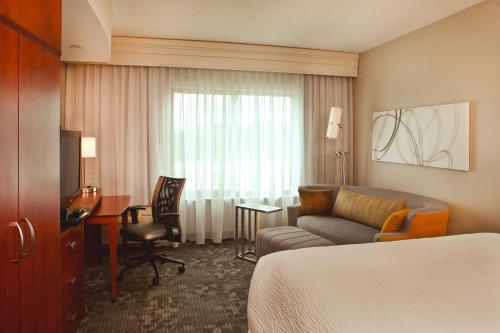 Habitación de hotel con cama, sofá y escritorio en Courtyard by Marriott Gettysburg, en Gettysburg