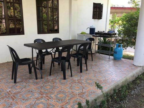 a black table and chairs on a tile patio at Riverside Transient House/Balingasay-Patar Beach in Balingasay