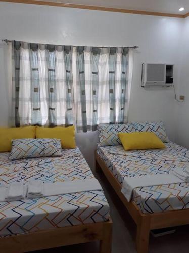 Кровать или кровати в номере Riverside Transient House/Balingasay-Patar Beach