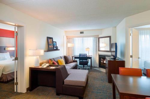 a hotel room with a couch and a bed and a desk at Residence Inn Boston Framingham in Framingham