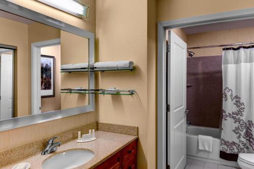 ein Bad mit einem Waschbecken, einem Spiegel und einer Dusche in der Unterkunft Residence Inn Atlanta Midtown 17th Street in Atlanta