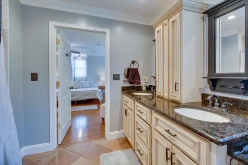 a bathroom with two sinks and a bedroom at Cozy Virginia Vacation Rental with Seasonal Pool! in Nokesville