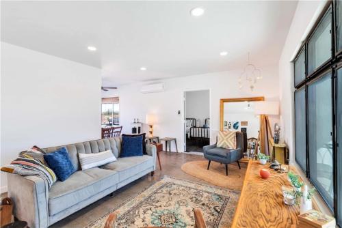 a living room with a couch and a table at Cozy Fresh Desert Hideaway, 5 mins to Joshua Tree in Twentynine Palms