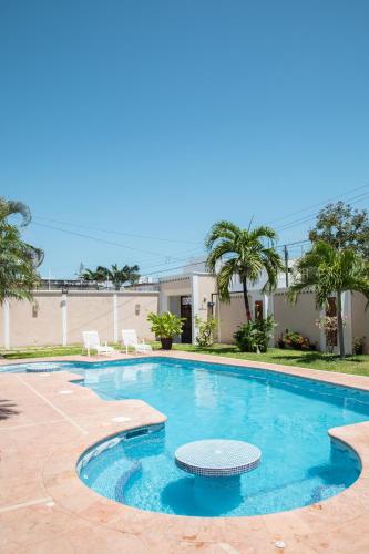 a swimming pool with a table and chairs in front of a building at Casa privada con alberca grande in Chetumal