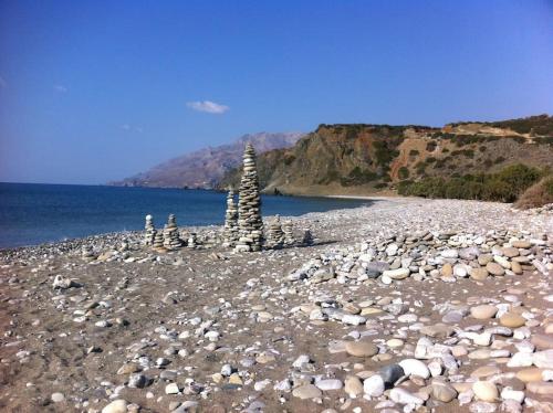 a rocky beach with two towers on the water at Mini Villas Blue in Keratokampos