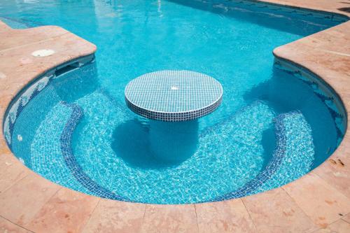 a pool with a table in the middle of the water at Casa privada con alberca grande in Chetumal