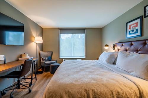 a hotel room with a bed and a desk and a window at Four Points by Sheraton Brunswick in Brunswick