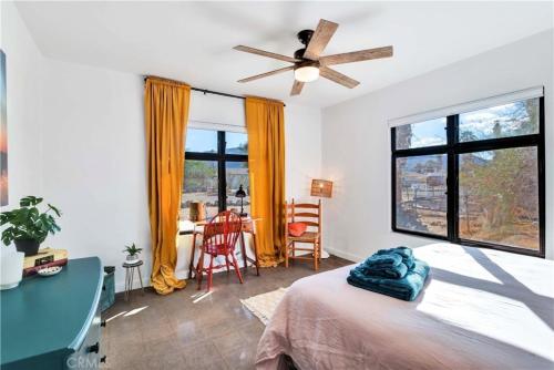 1 dormitorio con 1 cama, escritorio y ventanas en Cozy Fresh Desert Hideaway, 5 mins to Joshua Tree, en Twentynine Palms