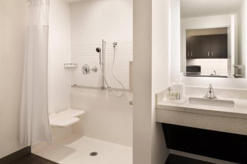 a bathroom with a toilet and a sink and a shower at TownePlace Suites by Marriott Dubuque Downtown in Dubuque