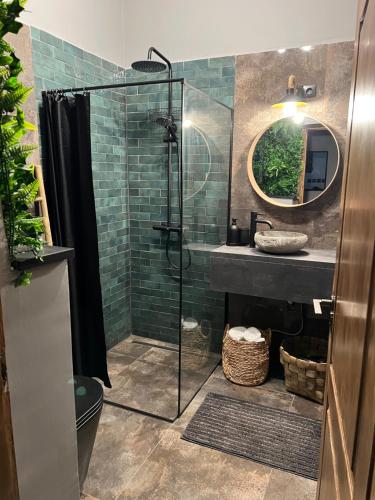 uma casa de banho com uma cabina de duche em vidro e um lavatório. em Jungle Inn em Budapeste